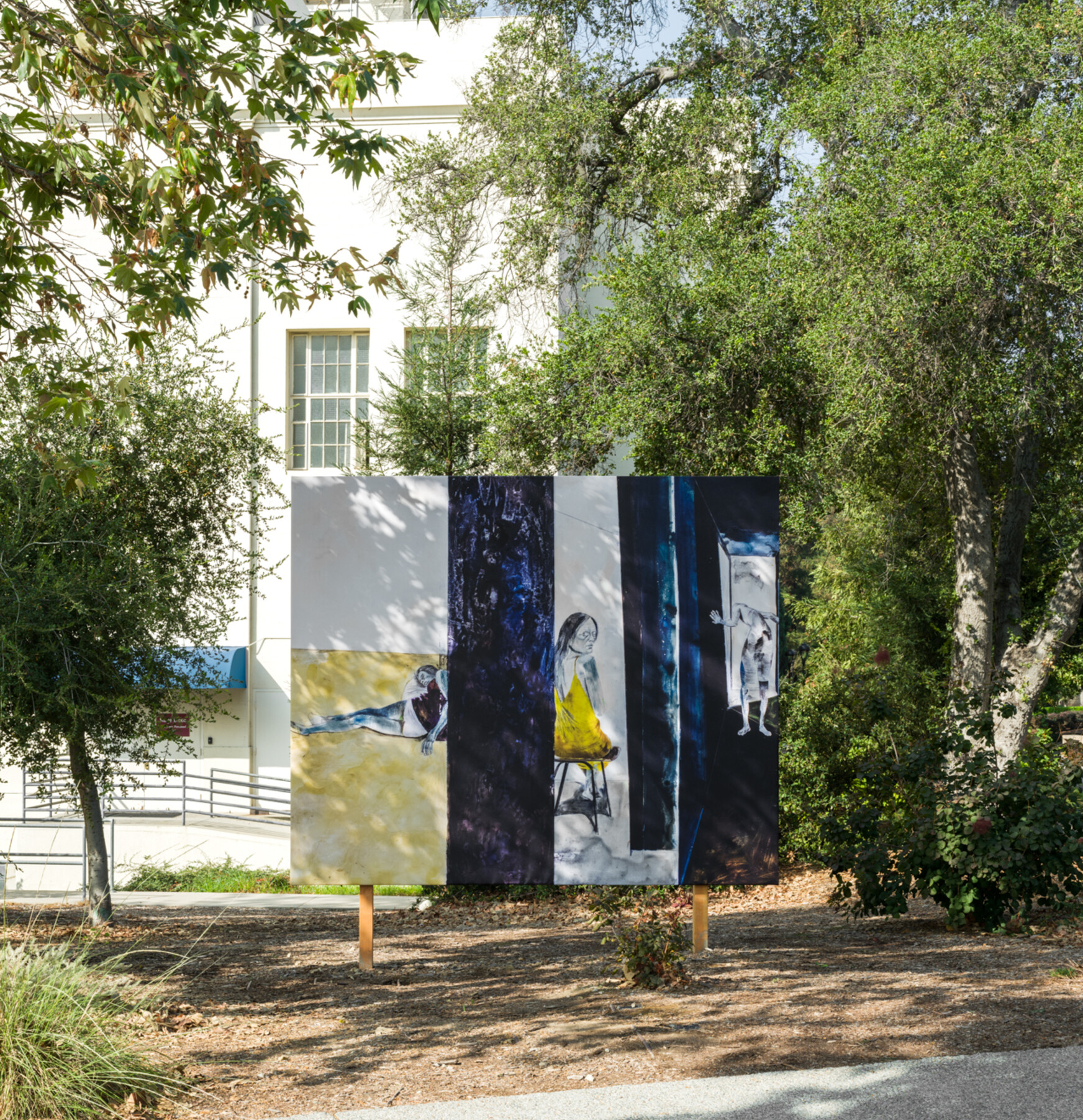 billboard shadowed in dappled light among trees in front of a white building