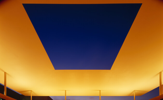 yellow-orange lighting on roof structure with square opening over a pool 