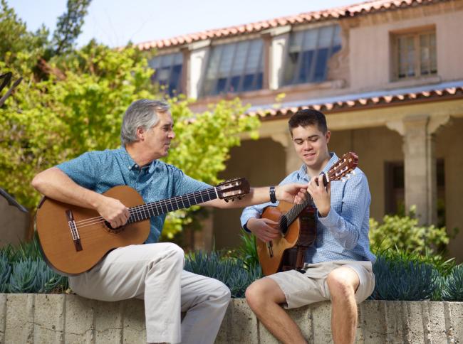 Professor instructing student during guitar lesson