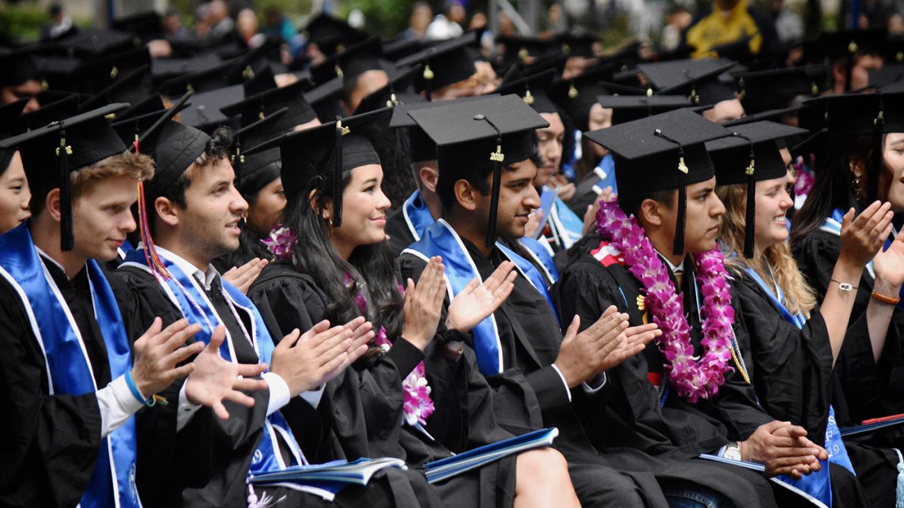 students clapping at commencement